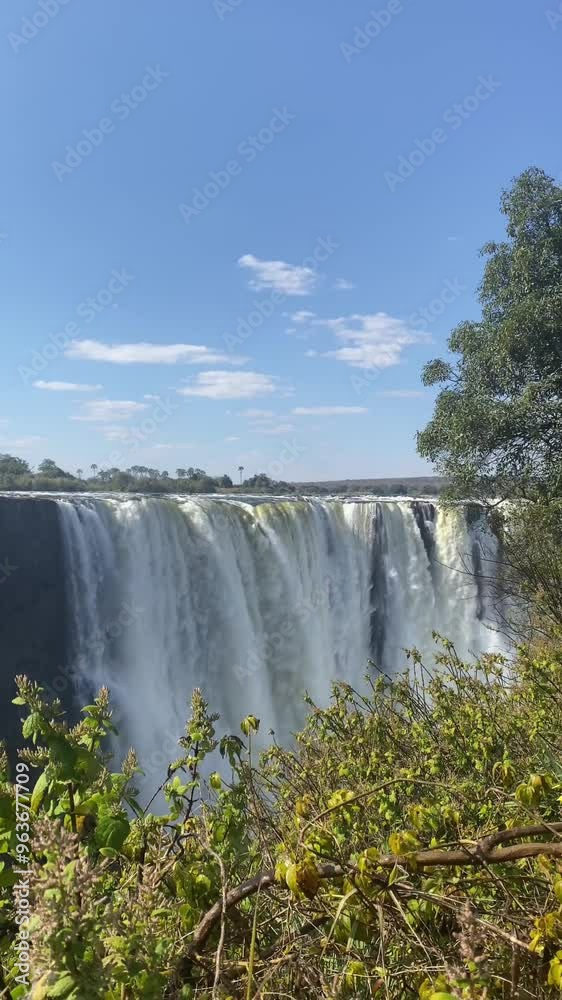 Video of the Victoria Falls, which forms the border between Zimbabwe, Zambia and Botswana. The waterfall is very deep, the vegetation is green and the area humid. The power of the water is impressive. Video of the Victoria Falls, which forms the border between Zimbabwe, Zambia and Botswana. The waterfall is very deep, the vegetation is green and the area humid. The power of the water is impressive.
