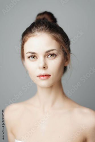 Beautiful young woman with a white towel on her head isolated on a gray background