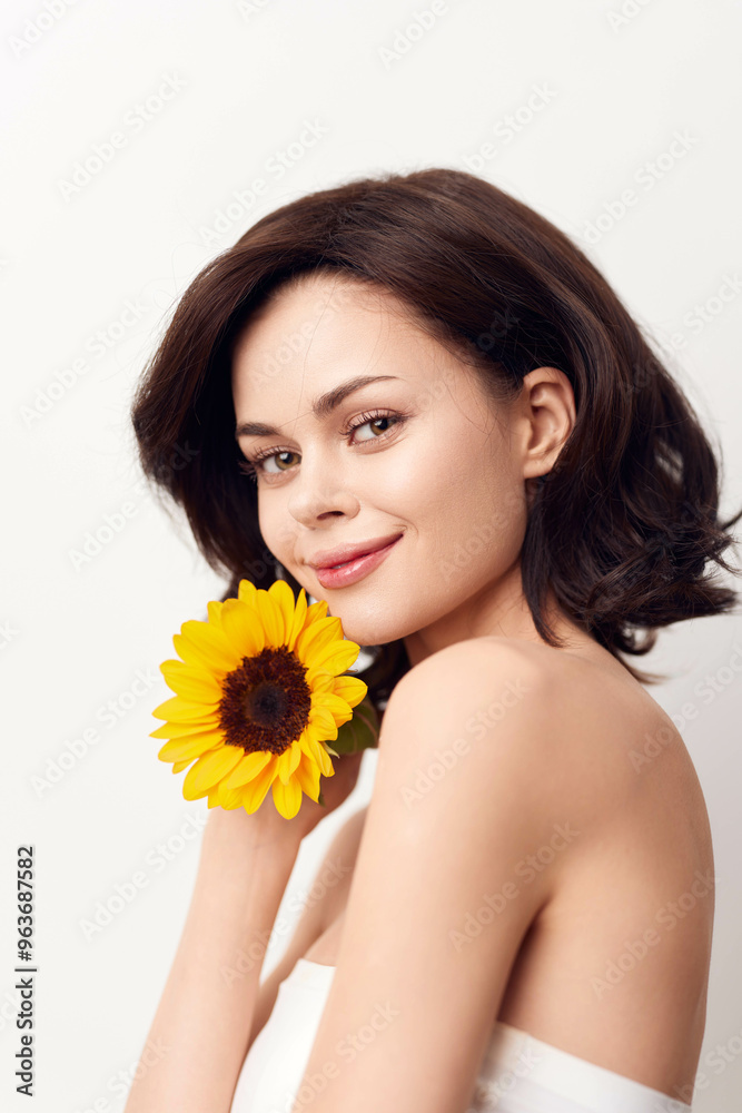 Beautiful young woman holding a sunflower on a white background Beautiful young woman holding a sunflower on a white background