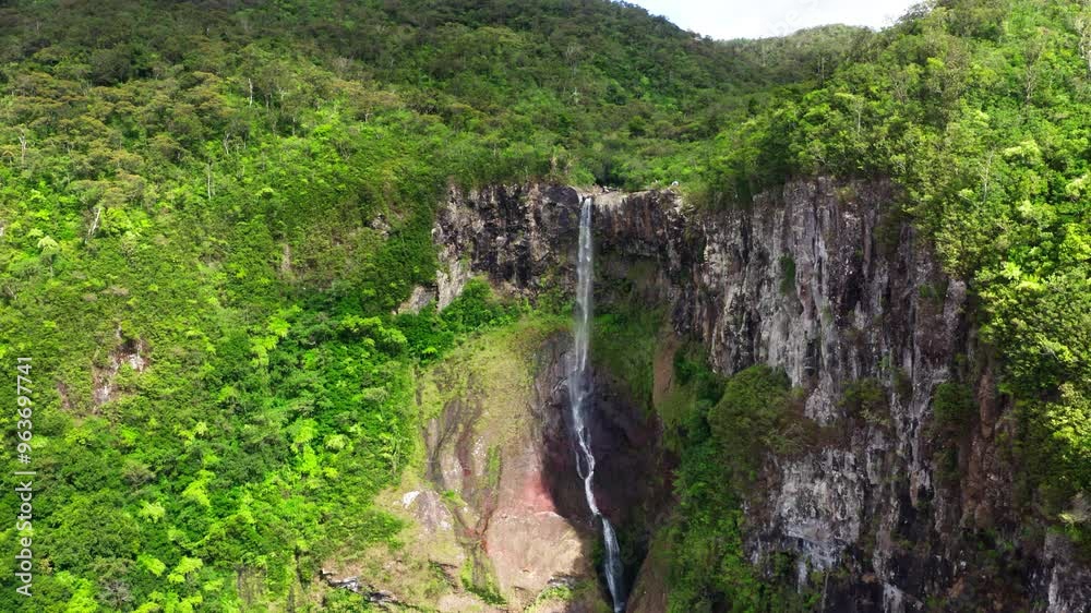 Picturesque flying over the mountain creek fall down from steep high cliff to wide green jungle valley. Cascade 500 Pieds waterfall also known as Cascade des Galets on Mauricius island in Indian ocean