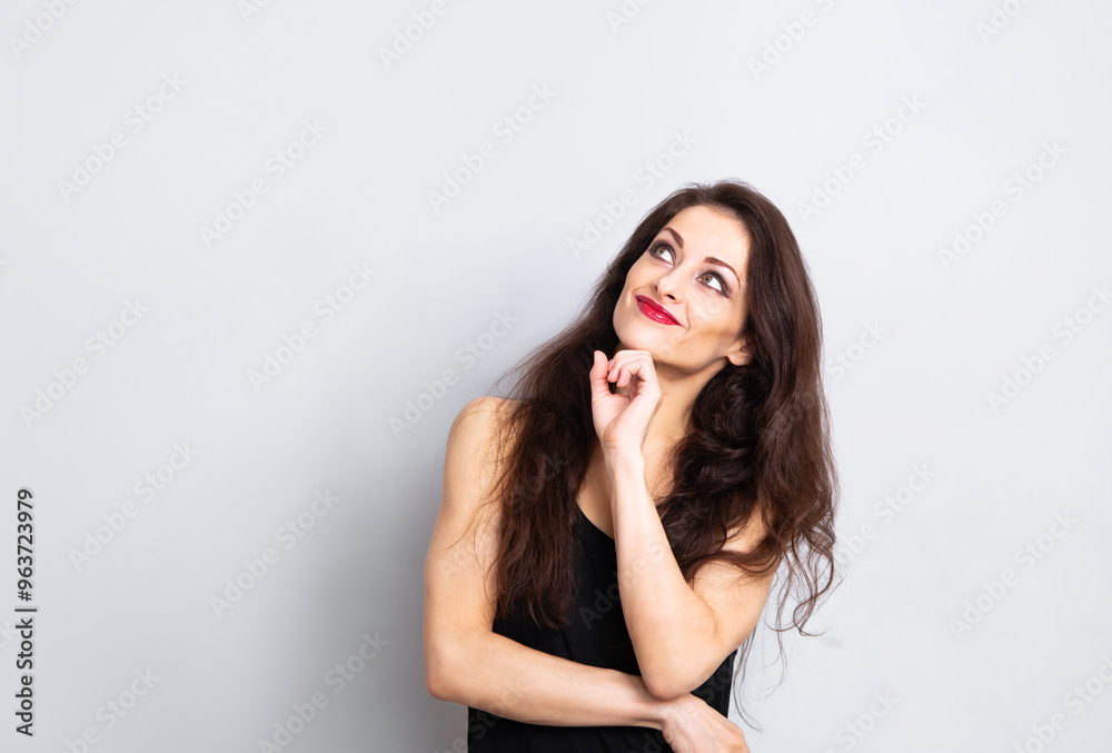 Happy enjoying make-up woman with red lipstick looking happy up in black top on white empty copy space blue background. with red lipstick Portrait Happy enjoying make-up woman with red lipstick looking happy up in black top on white empty copy space blue background. with red lipstick Portrait