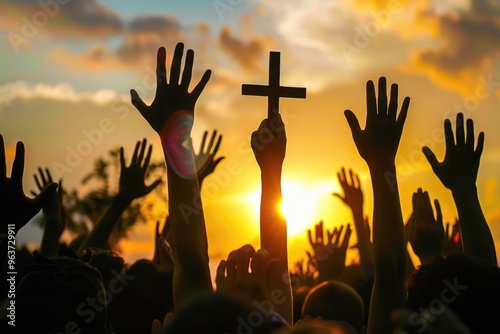 People gathered together holding up their hands in reverence, near a Christian symbol