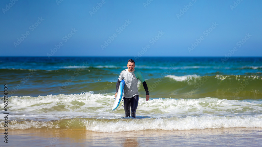 Man learning to surf on foam in the ocean. First surfing lesson. Amateur surfer. Surfing training. Photo for surfing school advertising on social media. Man learning to surf on foam in the ocean. First surfing lesson. Amateur surfer. Surfing training. Photo for surfing school advertising on social media.