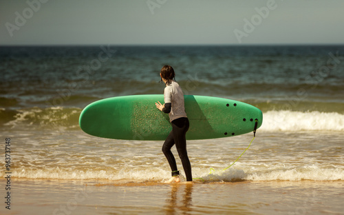 Photography Teenage girl learning to surf on foam in the ocean