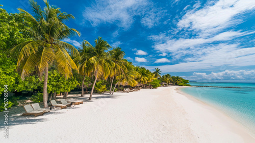 Tropical sea beach scene with clear turquoise water, white sandy shore and palm trees under a bright blue sky on a sunny day