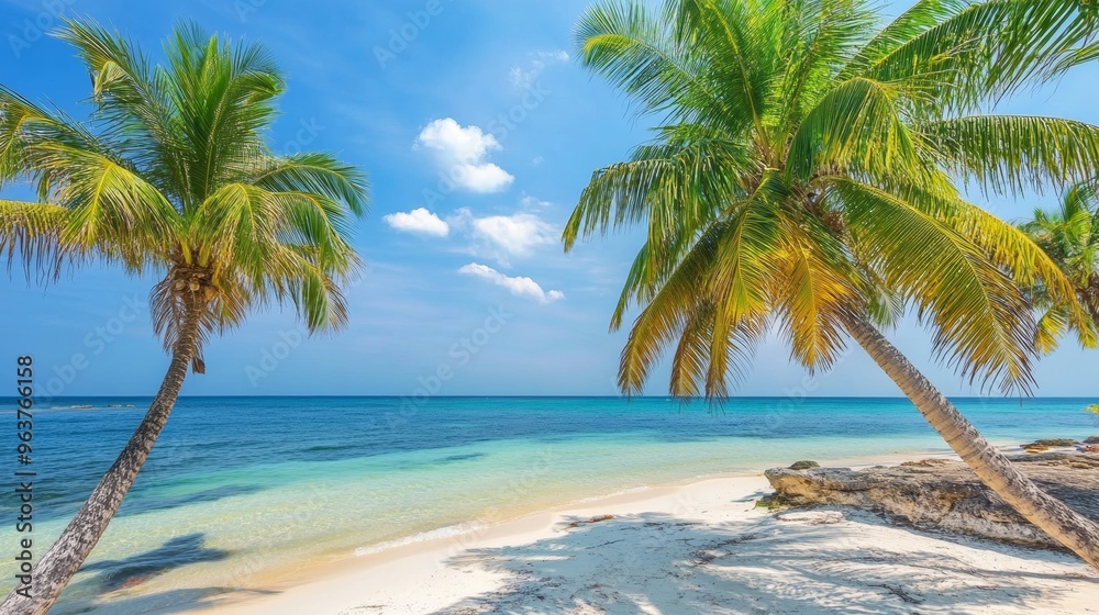 Fototapeta premium Tropical sea beach scene with clear turquoise water, white sandy shore and palm trees under a bright blue sky on a sunny day