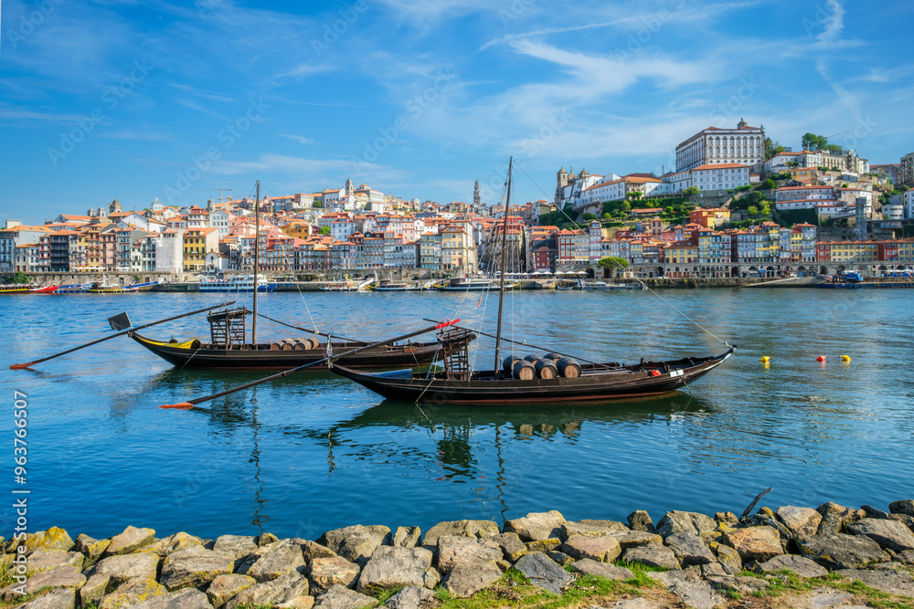 Obraz premium View of Porto city and Douro river with traditional boats with port wine barrels from famous tourist viewpoint Marginal de Gaia riverfront. Porto, Vila Nova de Gaia, Portugal
