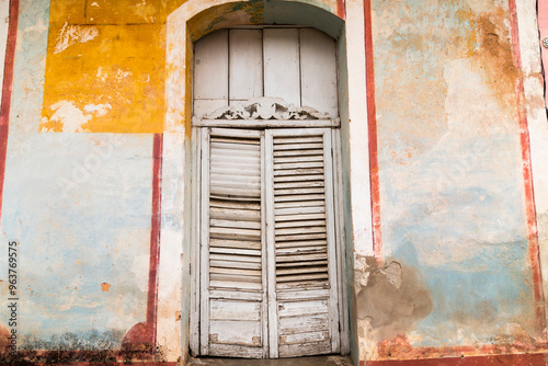 Cuba, Havana. Stucco and wood building, Shuttered, louvered doors. Blue and yellow, peeling paint. 2016-03-29