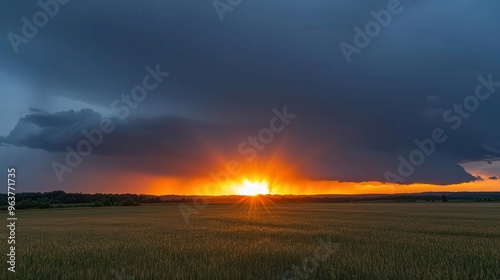 Sun setting behind a line of thunderstorms on the horizon, dramatic weather, contrast of light and dark