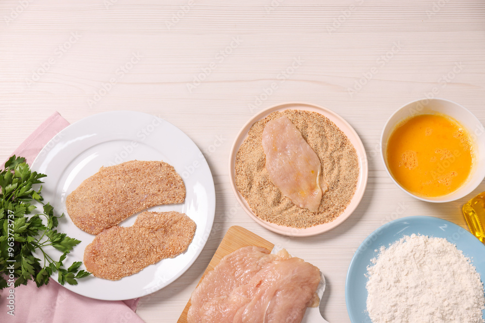 Making schnitzel. Slices of meat with bread crumbs and ingredients on white wooden table, flat lay Making schnitzel. Slices of meat with bread crumbs and ingredients on white wooden table, flat lay