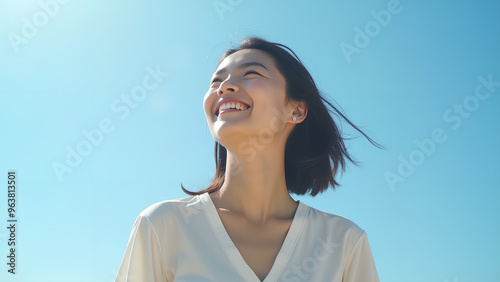 Happy Woman Under Blue Sky Asian Woman Smiling in Sunlight