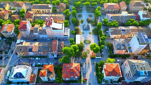 Aerial top down truck right shot of the city. The central Piazza Mentana or Mentana Square, pictured here, presents trees and a monument to the fallen