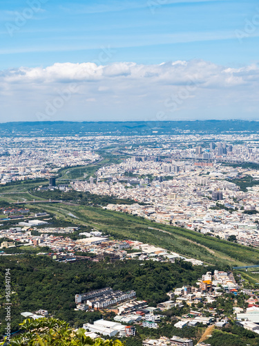 View of city from the beautiful mountain. Blue sky and green meadow in sunset time.