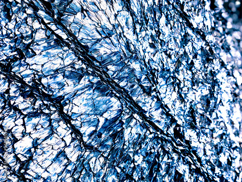 Phyllite A shiny phyllite with a crinkled surface and silvery sheen suspended to show its
