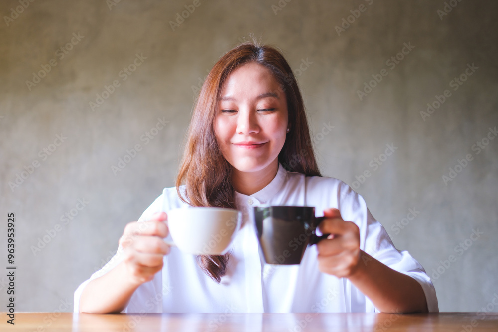 Portrait image of a young woman holding two cups of coffee Portrait image of a young woman holding two cups of coffee