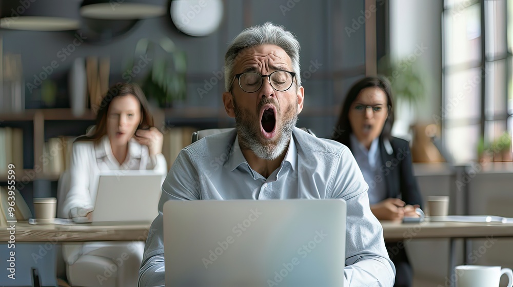 Fototapeta premium Middle-aged white businessman yawning during a long meeting, looking bored and tired. 