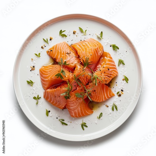 Sliced salmon fillet with fresh herbs on a white plate photo