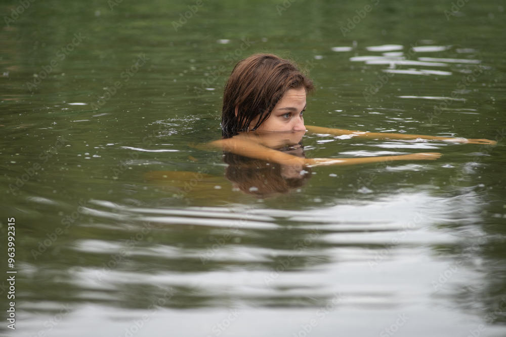 Beautiful young dark-haired girl by the river.