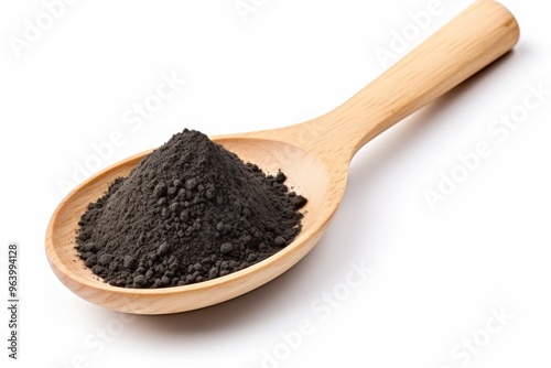 A wooden spoon holding fine black powder against a white background, highlighting its texture