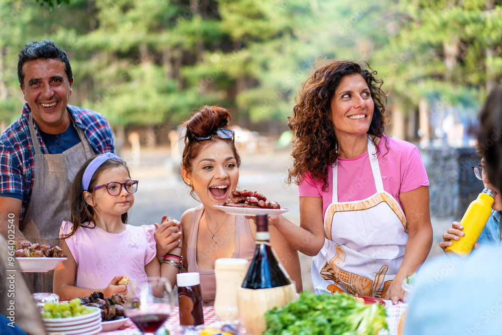Happy family enjoying outdoor barbecue, multigenerational picnic in nature, summer gathering with food Happy family enjoying outdoor barbecue, multigenerational picnic in nature, summer gathering with food