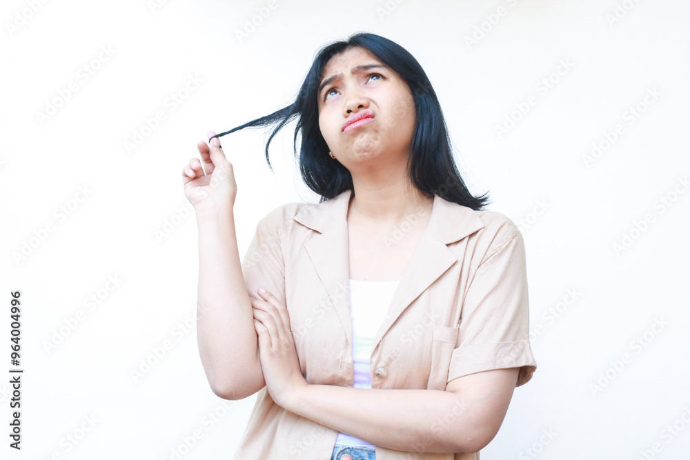 thougtful asian woman looking up to empty space and hold her hairs with pondering face expression wearing casual clothes isolated on white background thougtful asian woman looking up to empty space and hold her hairs with pondering face expression wearing casual clothes isolated on white background