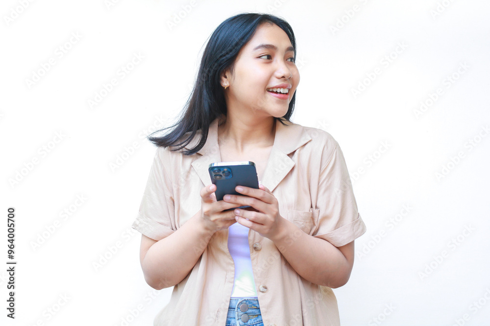 excited asian woman using smartphone and looking away wearing casual brown isolated on white excited asian woman using smartphone and looking away wearing casual brown isolated on white