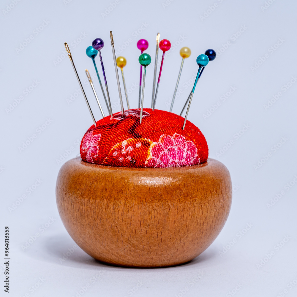 Sewing pins and needle cases on wooden stand isolated on white background
