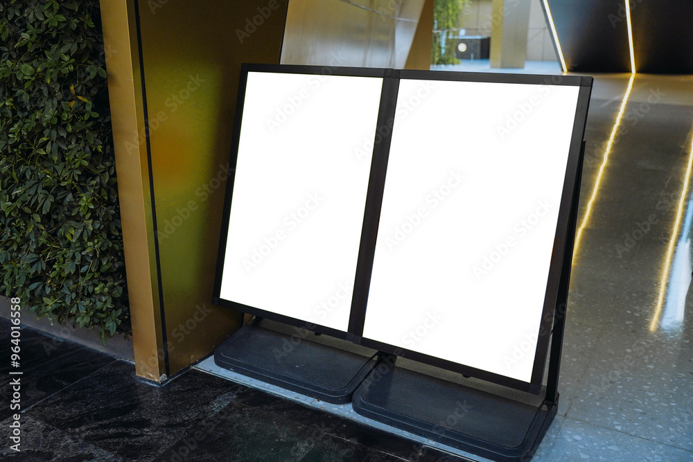 Blank white outdoor advertising stand or sandwich board mock up template. Clear street signage board placed by an outdoor dinning area of a restaurant. Background texture of standee on street.