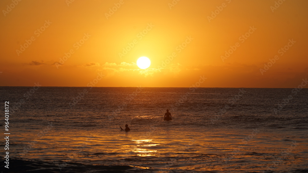 Fototapeta premium Surfers in the sunset hawaii oahu