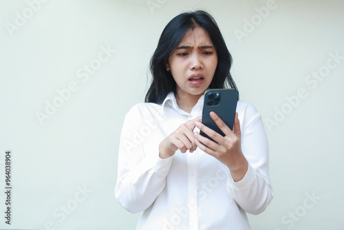 shocked asian business woman manager confused scrolling social mediaon  smartphone screen wearing white suit formal shirt, read bad news, surprised sale promo online shopping standing isolated