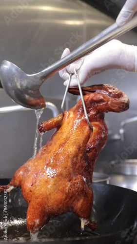 pouring hot oil over roasted duck 