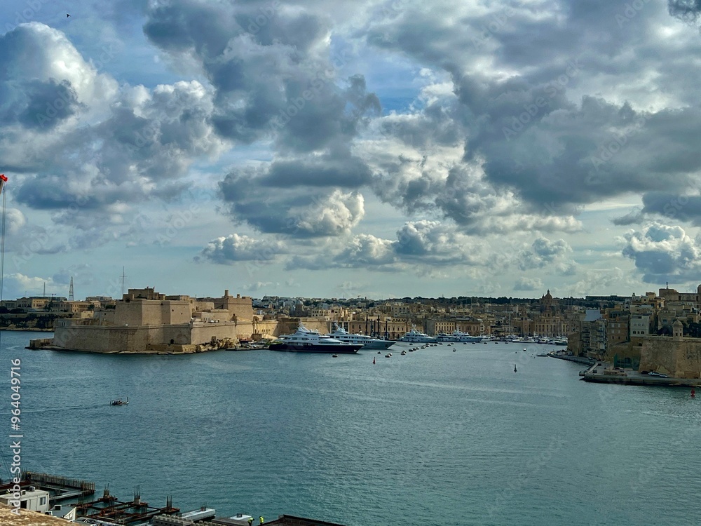 Naklejka premium Panoramic view of Valletta and the old port, Malta on a cloudy day.