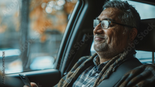 Smiling Older Indian Man Relaxing in Car Holding Phone