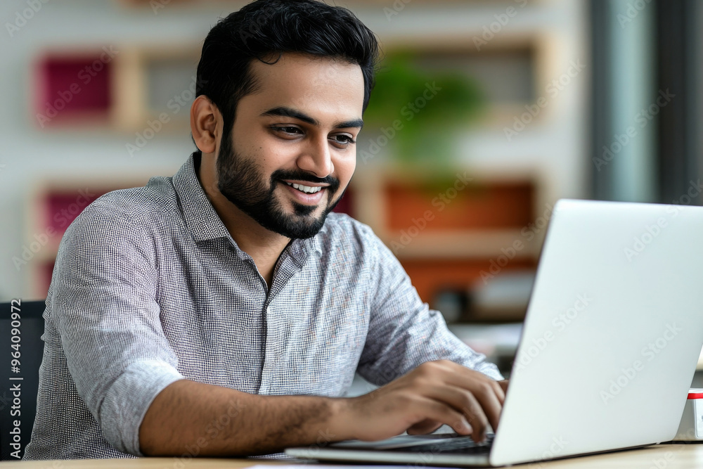 Handsome Indian Man Working on Laptop in Modern Office Setting Handsome Indian Man Working on Laptop in Modern Office Setting