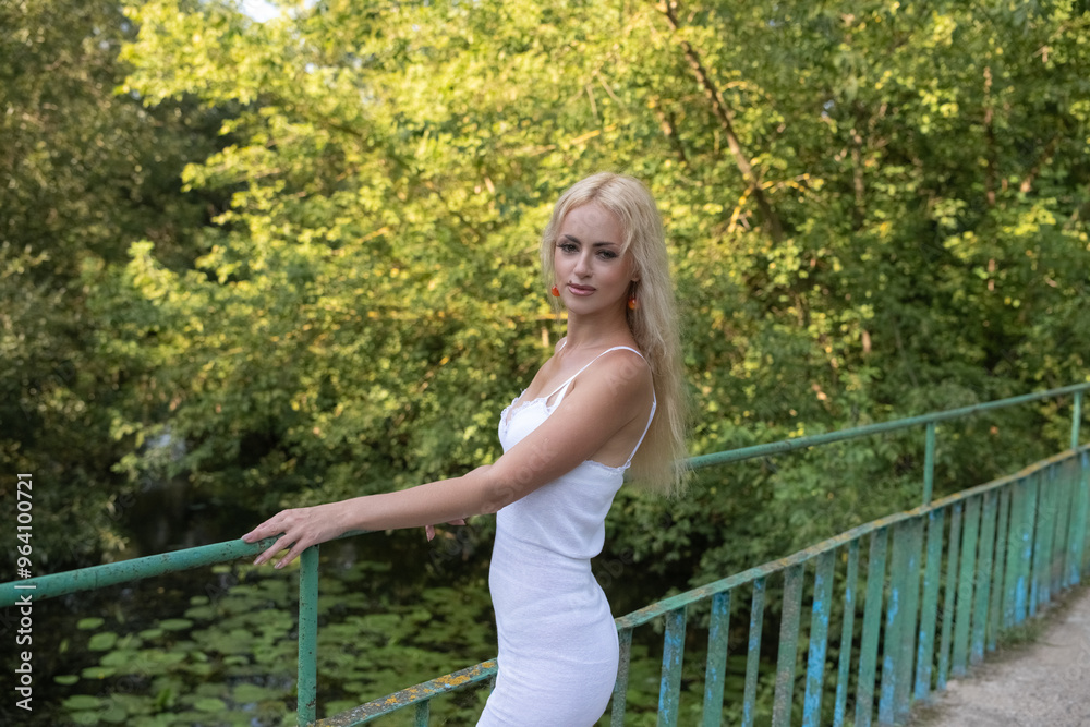 Naklejka premium Portrait of a young beautiful blonde girl in a summer forest.