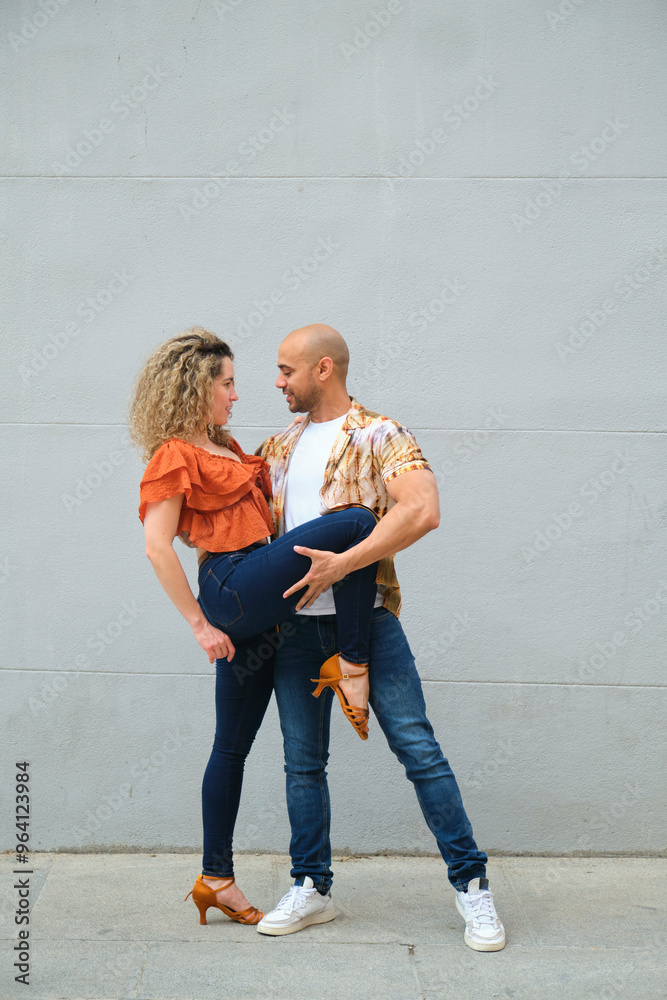 Couple of cuban dancers is performing salsa steps in the street