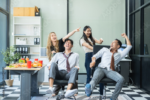 Asian business team are excited business success with inspiration from their excellent financial results, celebration successful deal with champagne and pizza in the workplace.