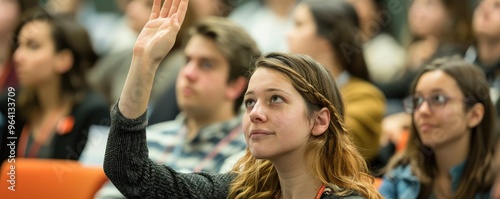 A highly engaged student raising his hand to participate in a diverse classroom, highlighting eagerness and active involvement in the learning process photo