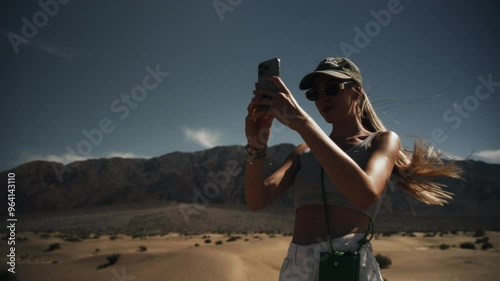 Wallpaper Mural Young attractive caucasian blonde woman taking photos with her phone in Death Valley national park, USA Torontodigital.ca