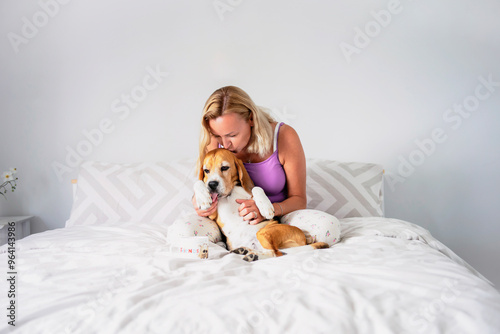 Wallpaper Mural happy woman 50 years old hugging her serious dog on bed in the morning Torontodigital.ca