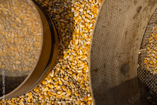 Crushed corn and the sieve and sieve required for processing in a photo.