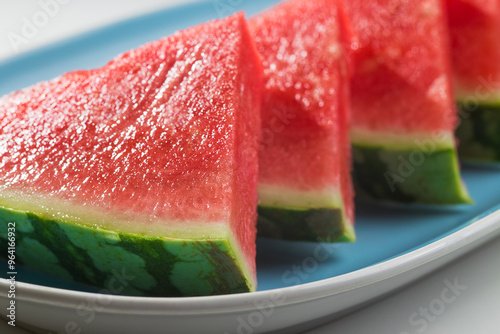 Watermelon with a triangle shape placed on a ceramic tray,