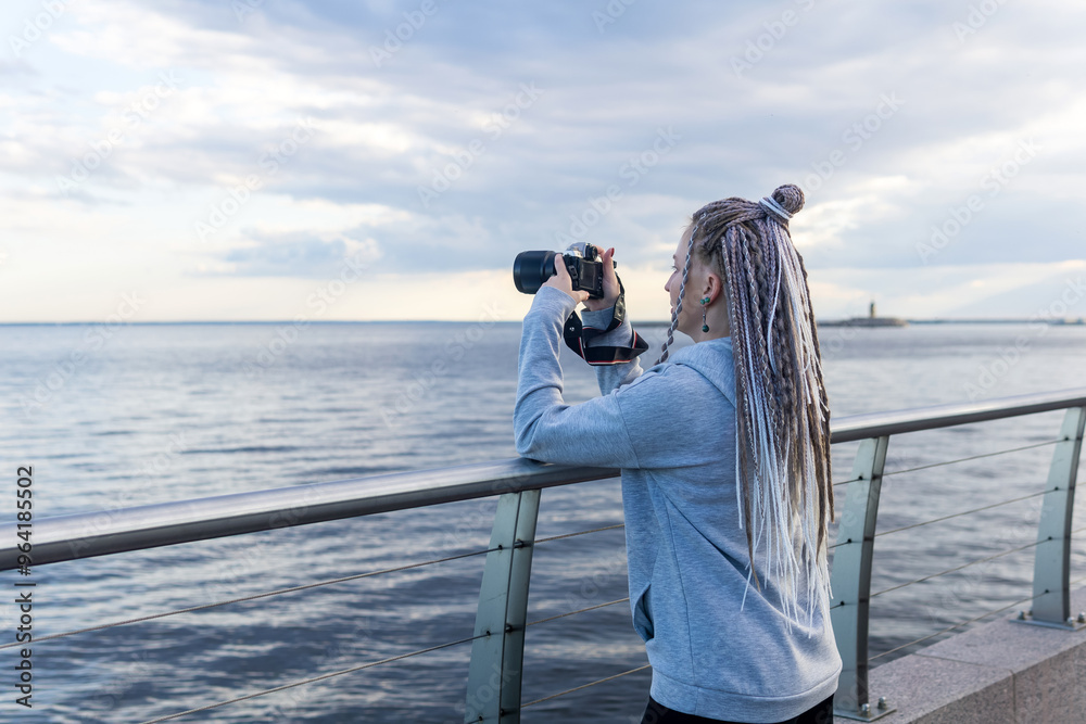 Obraz premium female tourist takes photo on embankment