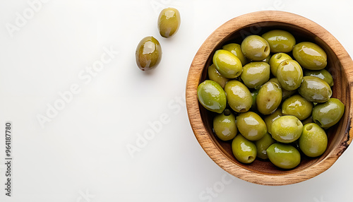 Wooden bowl with green olives on white background photo