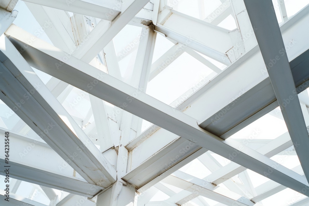 Obraz premium Architectural detail of overlapping white steel beams, creating a geometric pattern against a bright sky, evoking modernity and structural elegance.