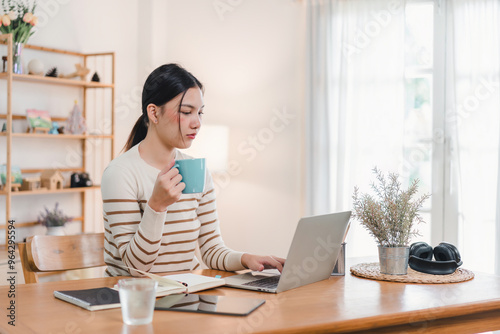 Asian businesswoman working on laptop at home office.