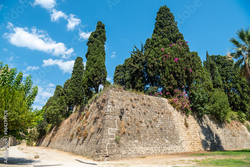 Medieval moat surrounding the walls of Old Town neighbourhood in Rhodes Town, Greece. The broad moat, now filled with lush gardens, separates the inner and outer walls of the city. photo