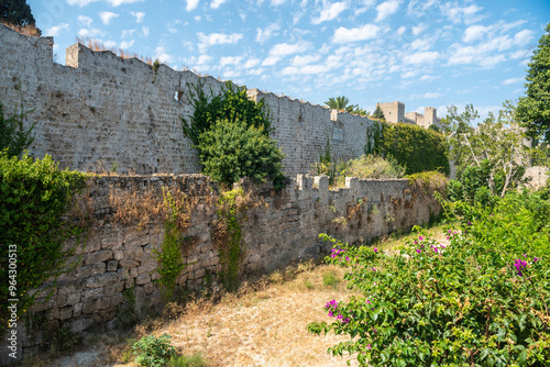 Medieval moat surrounding the walls of Old Town neighbourhood in Rhodes Town, Greece. The broad moat, now filled with lush gardens, separates the inner and outer walls of the city. 