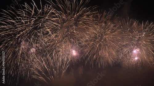 a vibrant fireworks display against a night sky in Busan, Korea. The spectacle illuminates the darkness with bursts of light and color, creating a festive atmosphere. photo