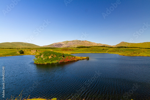 Snowdon or Yr Wyddfa mountain summit, Snowdonia or Eryri National Park lake and island in foreground wide angle.